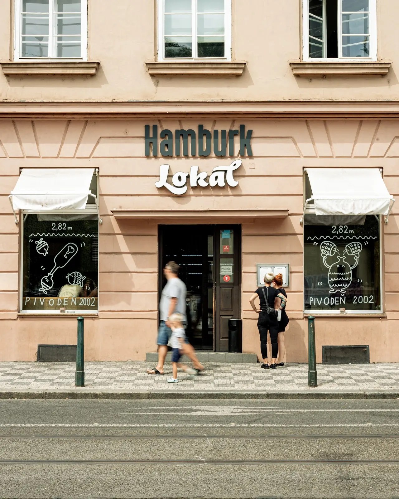 Exteriér restaurace Hamburg Lokál v Praze, historická fasáda s logem Lokál a vstupem z ulice.